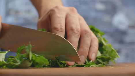 Primer-Plano-De-Perejil-Cortado-En-Una-Tabla-En-La-Cocina-Con-Un-Cuchillo